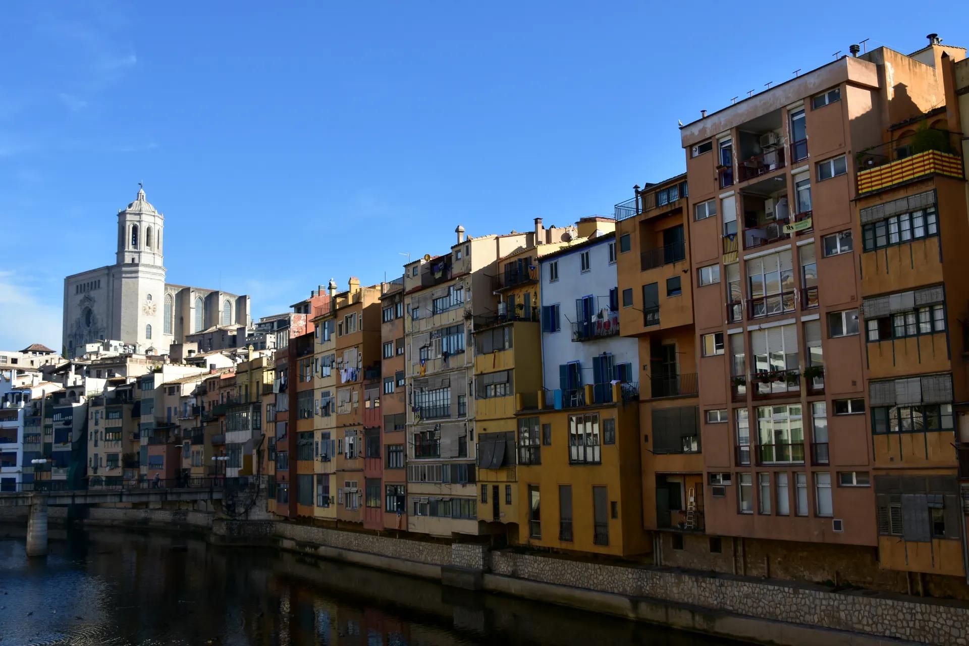 Coloured houses along the river Onyar in Girona with the cathedral behind