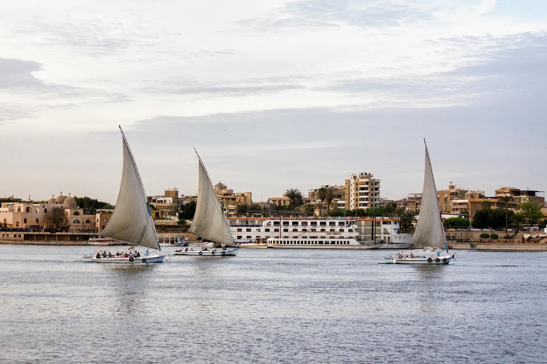 Three white-sailed feluccas on the Nile