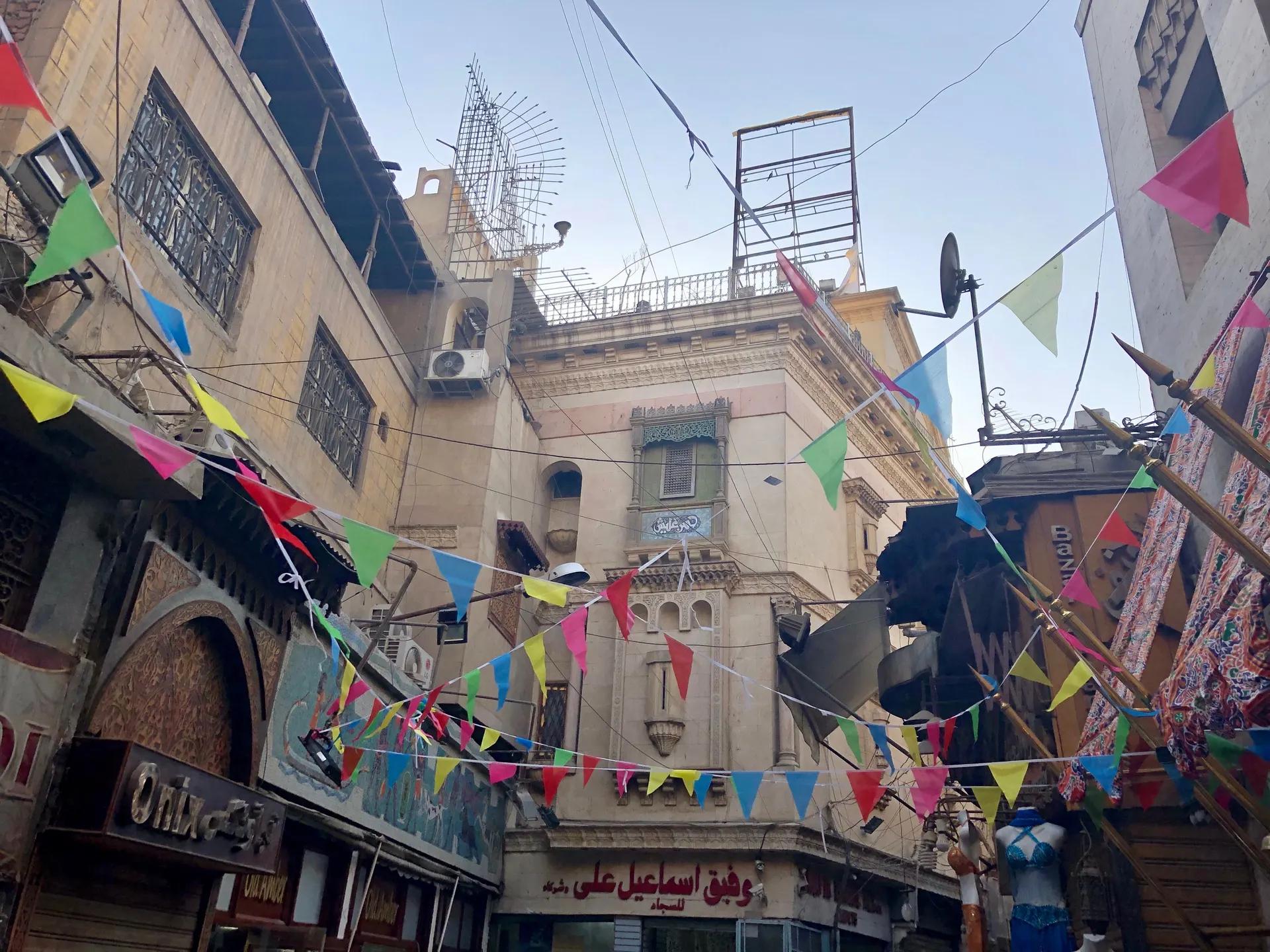 Lane in Khan el-Khalili hung with coloured bunting between old buildings
