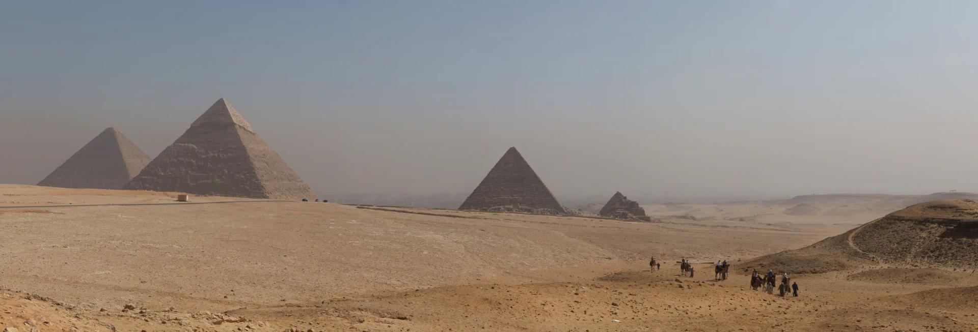 The three pyramids of Giza and the Queens' pyramids seen across the desert plateau