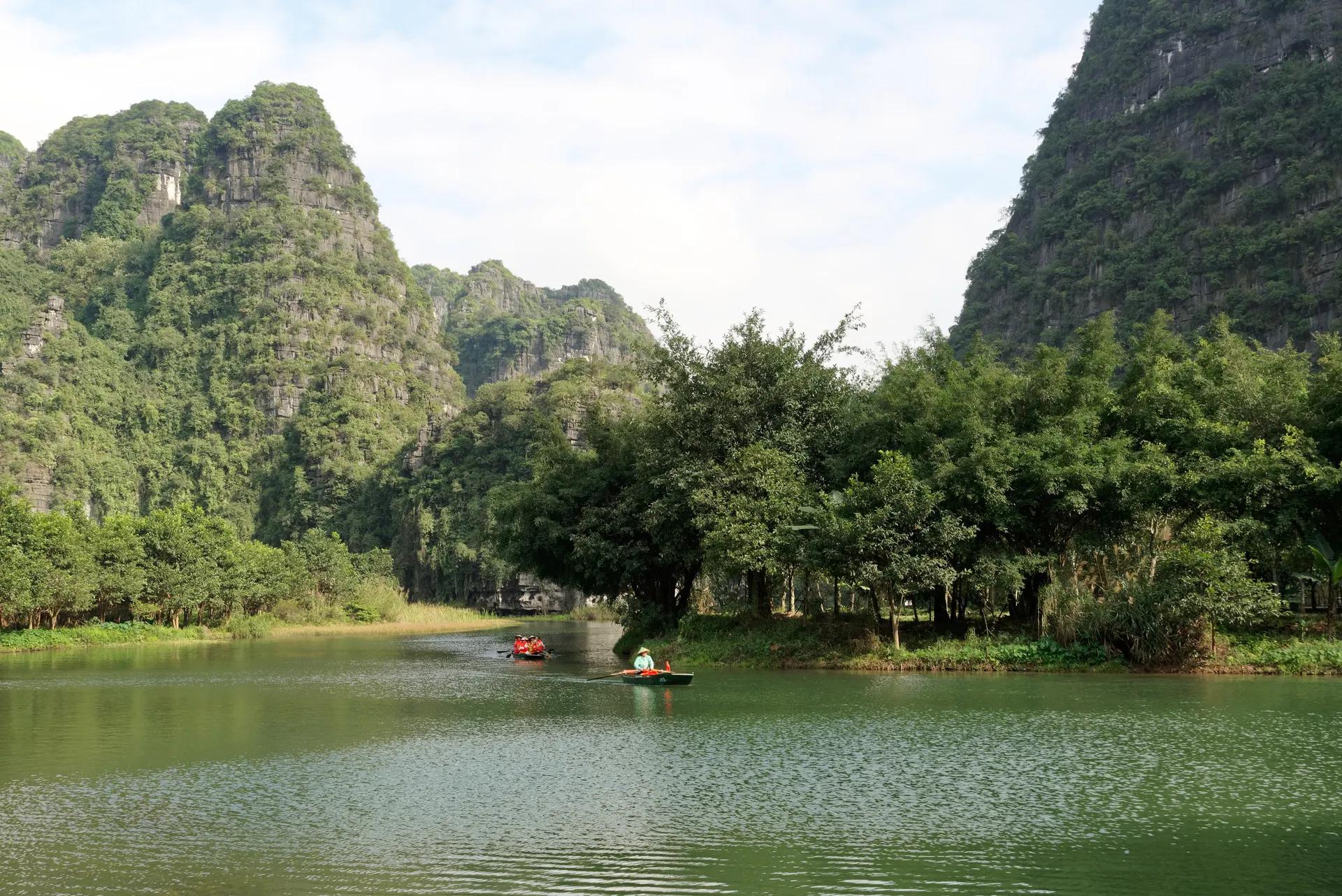 Rowing boats on a river between karst peaks at Trang An