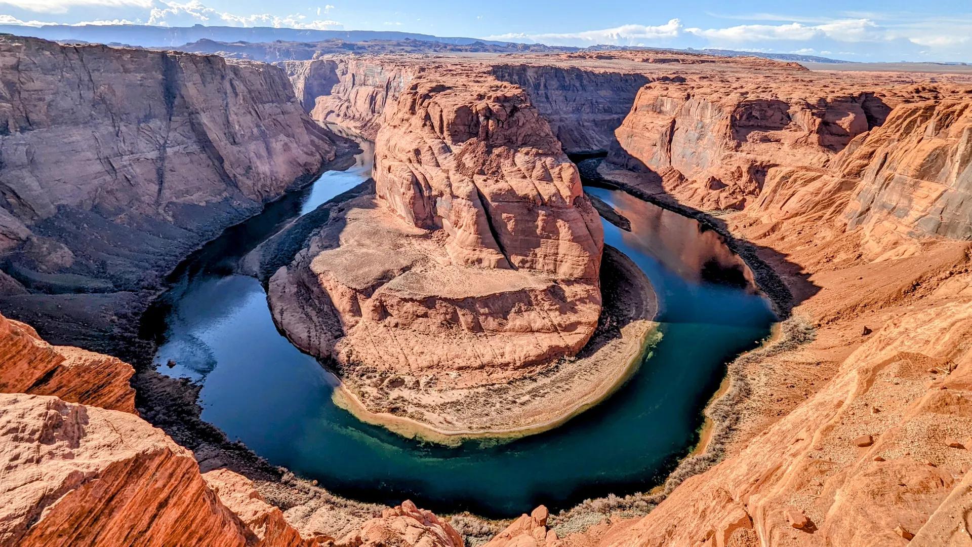 The Colorado River curving around Horseshoe Bend below sandstone cliffs