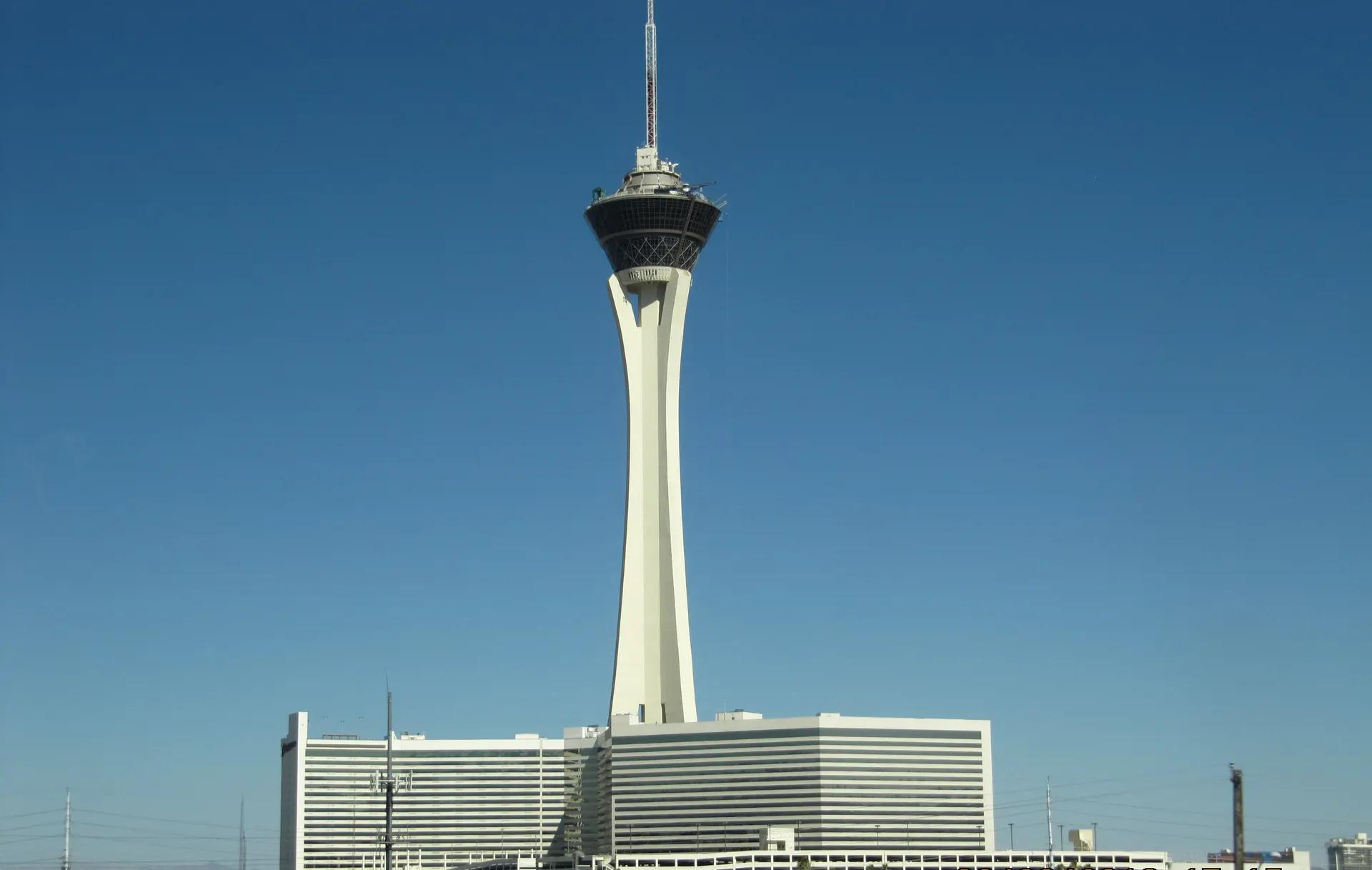 The Strat tower rising above its hotel against a blue sky