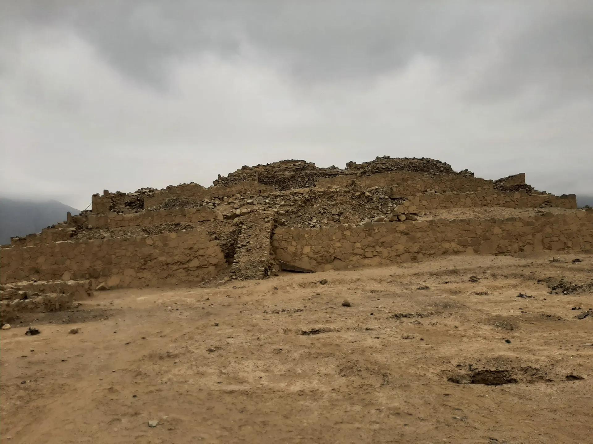 Stone platform pyramid at the Sacred City of Caral under a grey sky