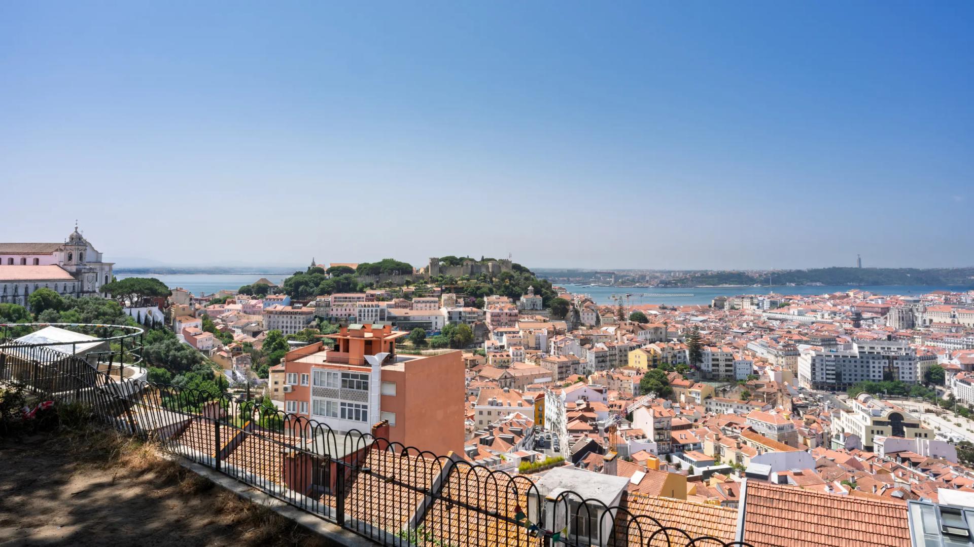 Lisbon rooftops with São Jorge Castle and the Tagus seen from Miradouro da Senhora do Monte