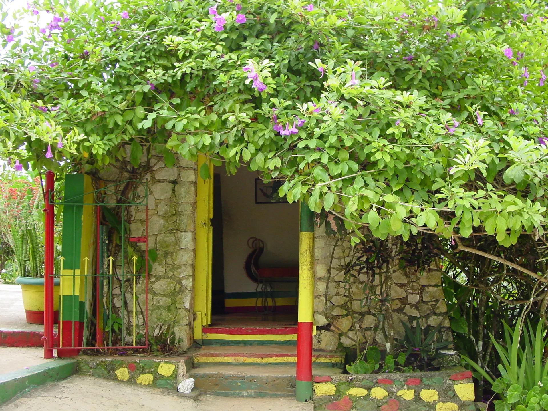 A small stone house painted in red, gold and green at Nine Mile, Bob Marley's birthplace