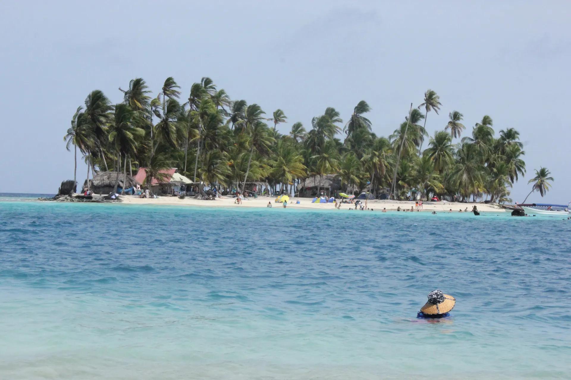 Palm-covered small island with a white beach in Guna Yala