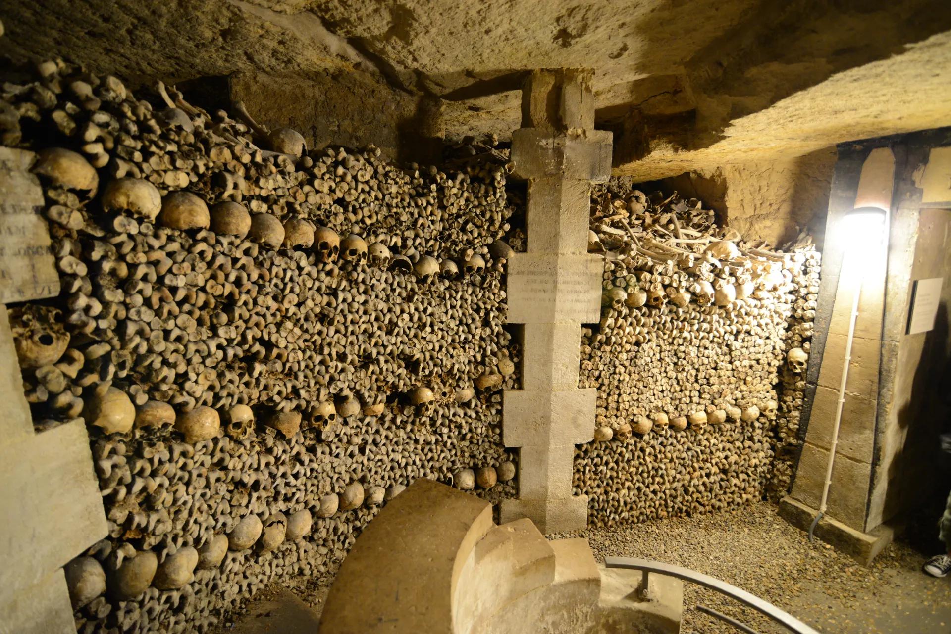 Walls of stacked skulls and bones in the ossuary of the Catacombs of Paris