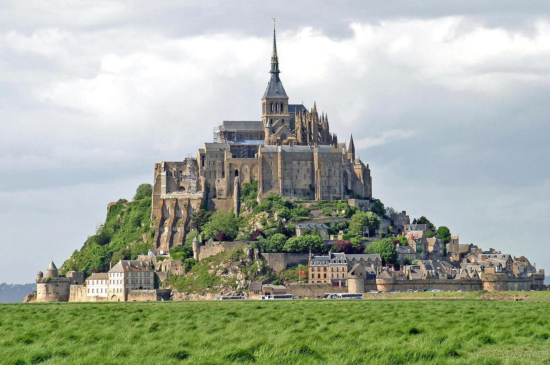 Mont-Saint-Michel abbey on its rocky island seen across salt meadows