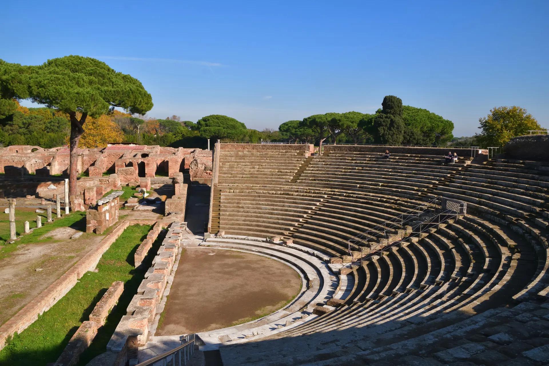 The semicircular Roman theatre at Ostia Antica surrounded by pine trees