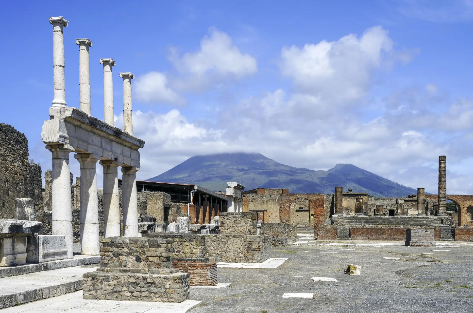 The Forum of Pompeii with columns and Mount Vesuvius behind