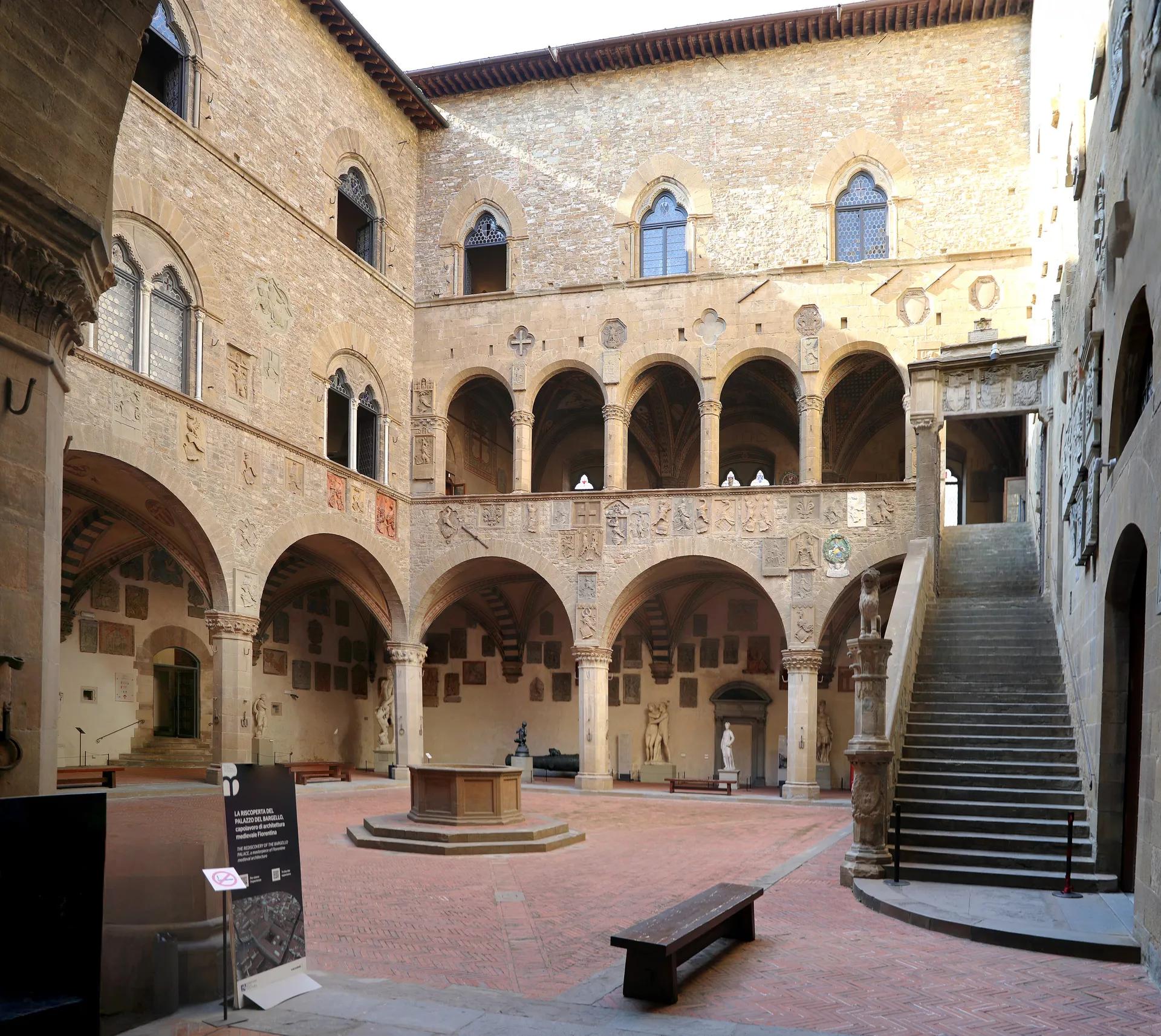 Courtyard of the Bargello with its arcade, outdoor staircase and coats of arms