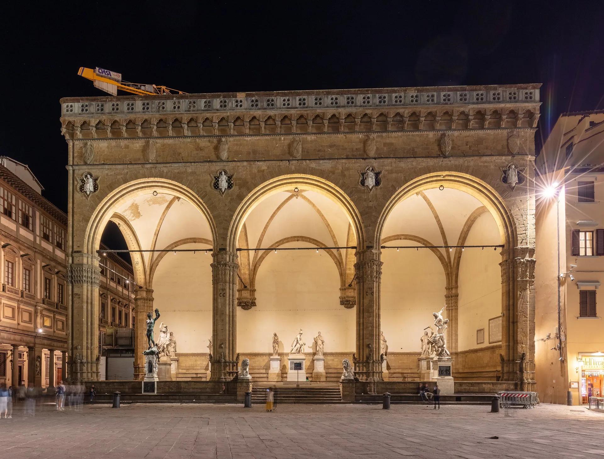 The three lit arches of the Loggia dei Lanzi with its statues at night