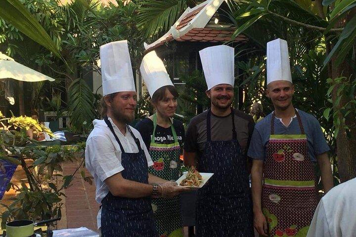 A aula de culinária tradicional Khmer no campo de arroz com vegetação