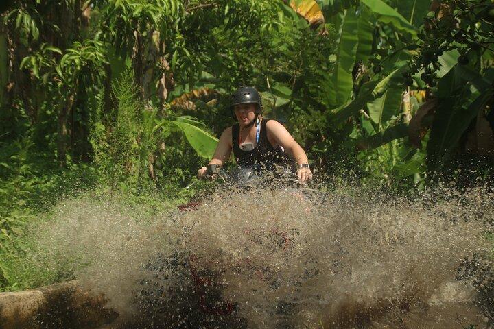 Quad ATV attraverso il tunnel e la cascata