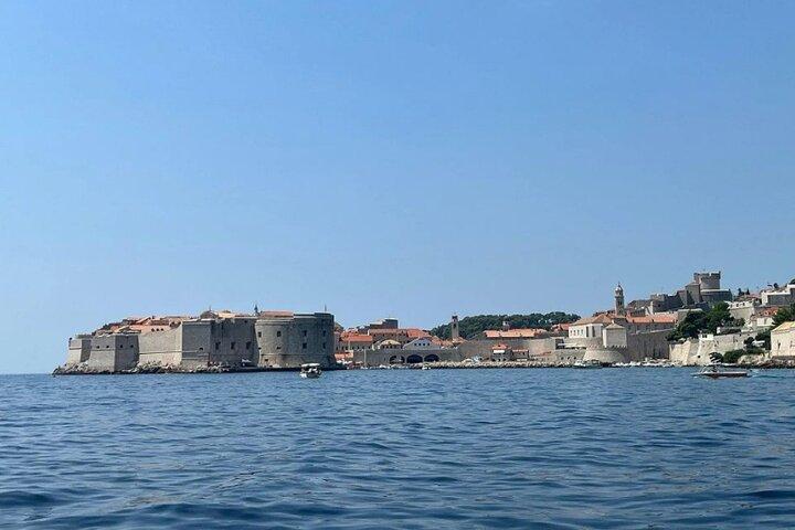 Panorama de barco de vidro / pôr do sol em torno da cidade velha de Dubrovnik e cavernas