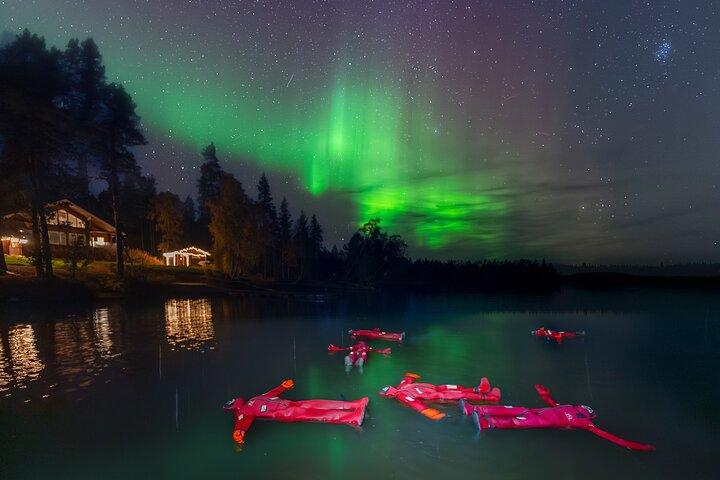 Ice Floating i skogsjö med Aurora Borealis