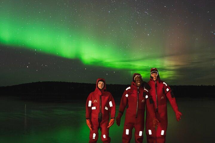 Ice Floating i skogsjö med Aurora Borealis