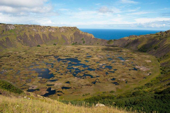 ラノ・カウ火口縁ハイキング ワイルドな崖と遠方の火山の景色